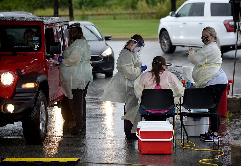 Health care providers participate Sept. 1 in a drive-through covid-19 testing clinic set up across from Baum-Walker Stadium at the corner of South Razorback Road and West 15th Street in Fayetteville. The city's board of health is asking for daily countywide antigen test results, in addition to the regularly reported daily PCR rest results, to get a better picture of covid activity in the community. (File photo/NWA Democrat-Gazette/Stacy Ryburn)