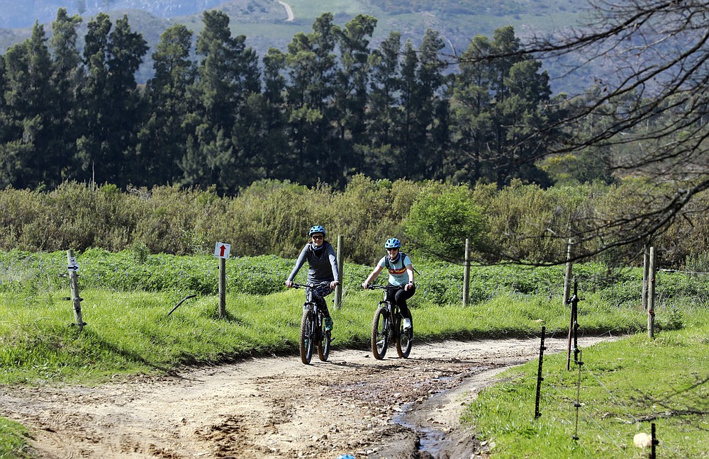 Local tourists are seen during an adventure e-bike tour, run by tour operator Raino Bolz, on the Boschendal Estate near, Cape Town, South Africa, Friday Sept. 4, 2020. Africa's tourism sector is struggling to cope with the drop in international travel caused by the COVID-19 pandemic. The World Travel and Tourism Council estimates the drop in travel caused by the COVID-19 pandemic will see Africa lose between $53 billion and $120 billion in contributions to its GDP in 2020. ( AP Photo/Nardus Engelbrecht)