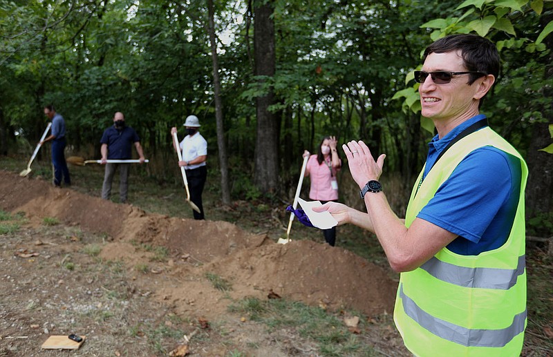 Peter Nierengarten, environmental director with the city of Fayetteville, applauds Thursday after the second group of four guests use sanitized shovels to turn dirt during a groundbreaking ceremony for the city's Cultural Arts Corridor in the Fay Jones Woods. The corridor is planned as a series of connected outdoor public spaces throughout downtown. Voters approved a $31.6 bond issue in April 2019 to make the project happen. Check out nwaonline.com/200911Daily/ and nwadg.com/photos for a photo gallery.
(NWA Democrat-Gazette/David Gottschalk)