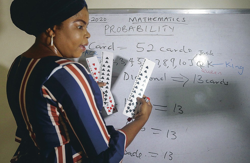Mathematics teacher Basirat Olamide Ajayi, 36, teaches probability theory with the aid of playing cards, online via her mobile phone from her house in Lagos, Nigeria Saturday, Aug. 15, 2020. The teacher from a Lagos public school is helping students across the country, and internationally, learn math virtually during coronavirus restrictions that have prevented most children from returning to class in Nigeria. (AP Photo/Sunday Alamba)