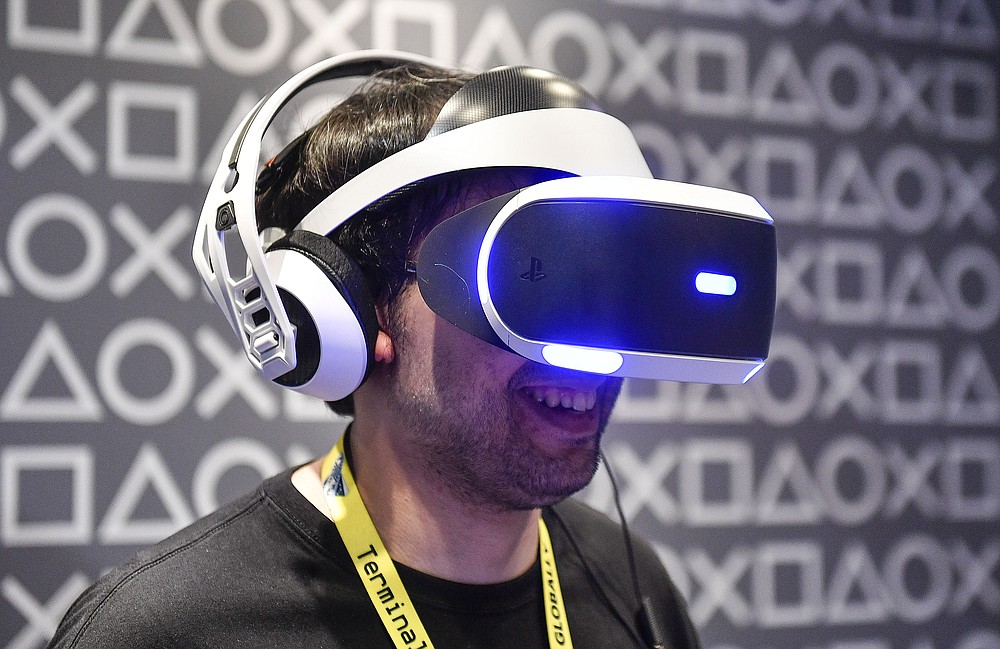 FILE - In this Aug. 20, 2019 file photo, a man testing a Sony PlayStation Virtual Reality headset at the Gamescom in Cologne, Germany. Streaming high-definition video and games can result in significant greenhouse gas emissions, depending on the technology used, according to a German government-backed study released Thursday. (AP Photo/Martin Meissner)