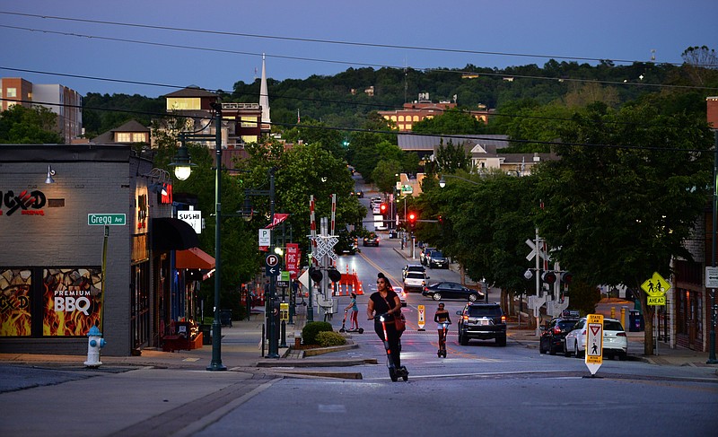 Residents ride electric scooters Friday, May 29, 2020, west on Dickson Street in Fayetteville. The City Council will consider a proposal to establish an outdoor refreshment area downtown in which patrons could take alcoholic drinks outside of businesses. Visit nwaonline.com/200531Daily/ for today's photo gallery.
(NWA Democrat-Gazette/Andy Shupe)