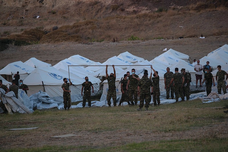 Greek soldiers set up tents at a shooting range Friday to accommodate refugees on the Greek island of Lesbos. More photos at arkansasonline.com/912lesbos/.
(AP/Petros Giannakouris)