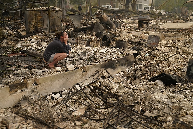 Desiree Pierce cries Friday in the ruins of her home in Talent, Ore., that was destroyed by wildfire. “I just needed to see it, to get some closure,” she said. More photos at arkansasonline.com/912fire/.
(AP/John Locher)