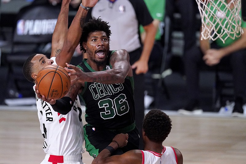 Boston Celtics' Marcus Smart (36) goes up for a shot against Toronto Raptors' Norman Powell, left, and Kyle Lowry during the second half of an NBA conference semifinal playoff basketball game Friday, Sept. 11, 2020, in Lake Buena Vista, Fla. (AP Photo/Mark J. Terrill)