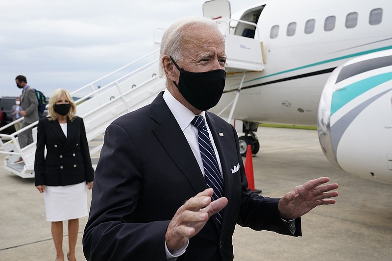 Democratic presidential candidate and former Vice President Joe Biden speaks with reporters after he and his wife Jill Biden, back left, stepped off a plane at New Castle Airport in New Castle, Del., Friday, Sept. 11, 2020. (AP Photo/Patrick Semansky)