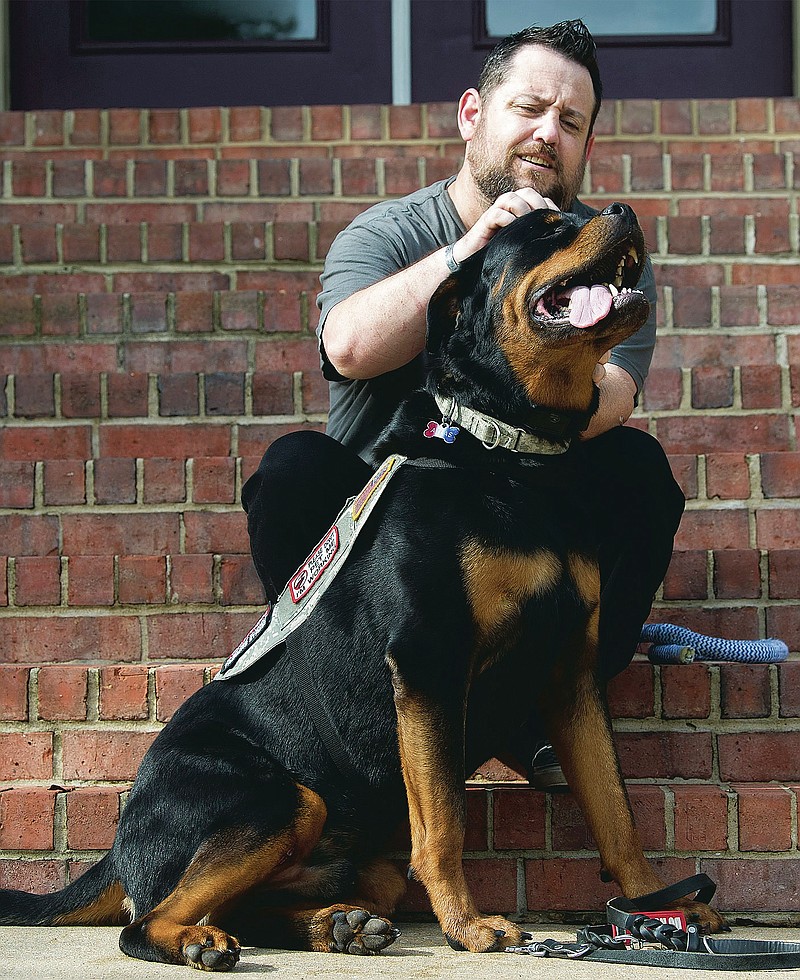 Perry Hopman plays with his service dog, Atlas, outside his home in Benton on Friday, Sept. 4, 2020. Atlas is trained to help Perry ward off panic attacks, anxiety, and flashbacks on the job as a result of his PTSD while serving as a U.S. Army flight medic.

(Arkansas Democrat-Gazette / Stephen Swofford)