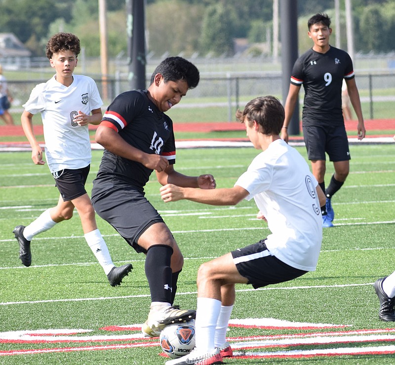 RICK PECK/SPECIAL TO MCDONALD COUNTY PRESS McDonald County's Alexis Pedrosa battles with a defender from College Heights for control of the ball during the Mustangs' 1-0 win on Sept. 8 at MCHS. Pedrosa scored the game's only goal with a header in overtime.