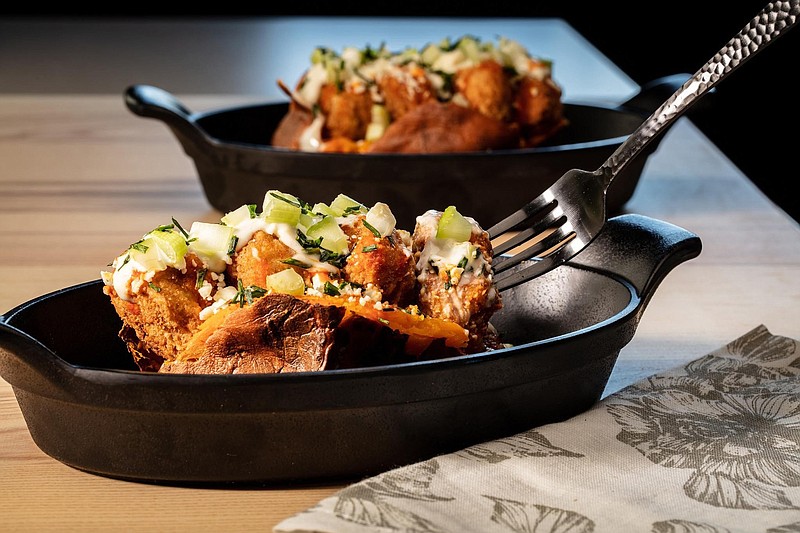The classic idea of a loaded baked potato becomes dinner all by itself. Here sweet potatoes take the place of russets, and Buffalo chicken wings inspire the toppings. Think crispy chicken nuggets, blue cheese and hot sauce. (Zbigniew Bzdak/Chicago Tribune/TNS) story.lead_photo.caption
