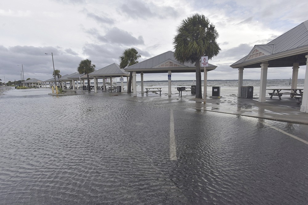 Storm surge floods a parking lot in Pensacola Beach, Fla., Monday, Sept. 14, 2020. Storm-weary Gulf Coast residents rushed to finish last-minute preparations Monday as Hurricane Sally chugged slowly through warm Gulf waters. Forecasters predicted the biggest threat is flooding, with as much as two feet of rain falling in some areas. (Tony Giberson/Pensacola News Journal via AP)