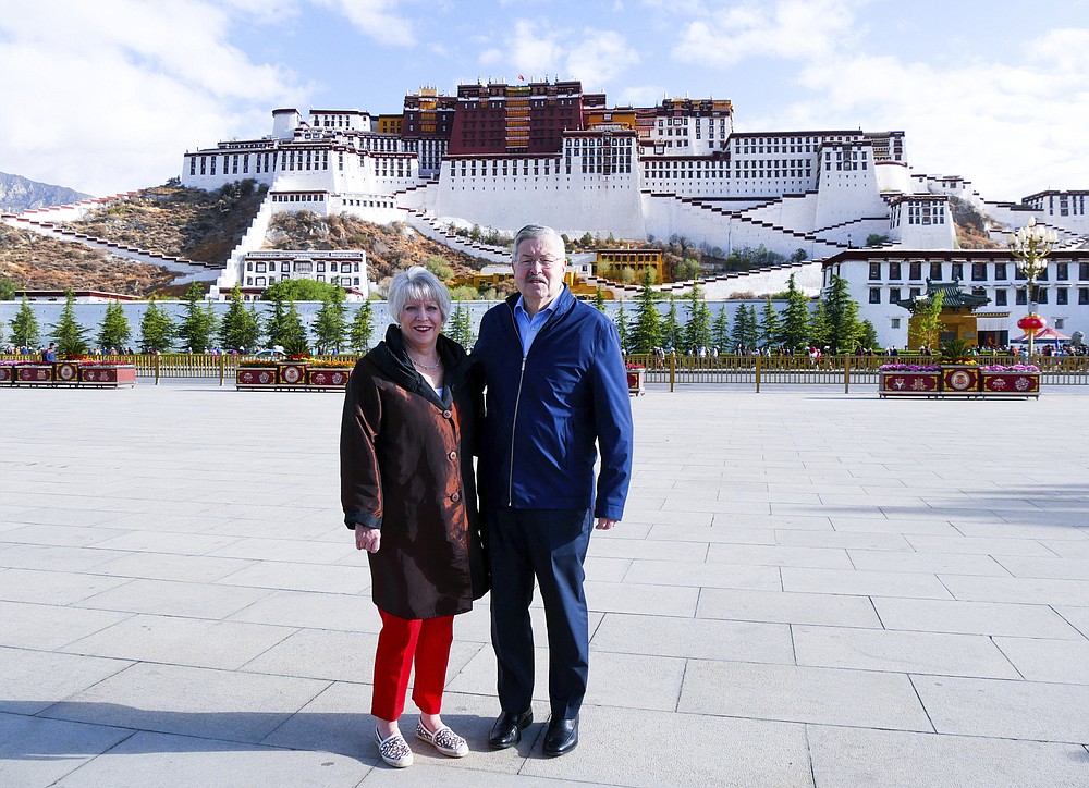 FILE - In this May 22, 2019 photo released by the U.S. Embassy in Beijing, U.S. Ambassador to China Terry Branstad and his wife Christine pose for a photo in front of the Potala Palace in Lhasa in western China's Tibet Autonomous Region. Branstad appears to be leaving his post, based on tweets by Secretary of State Mike Pompeo. Pompeo thanked Branstad for more than three years of service on Twitter on Monday, Sept. 14, 2020. (U.S. Mission to China via AP, File)
