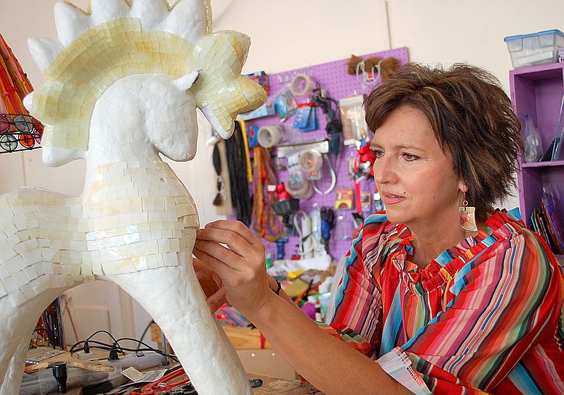 Janelle Jessen/Herald-Leader
Artist Amy Haid places hand-cut pieces of glass on a abstract pony sculpture at her new studio on downtown Siloam Springs. The mosaic sculpture already has more than 2,000 pieces of glass.