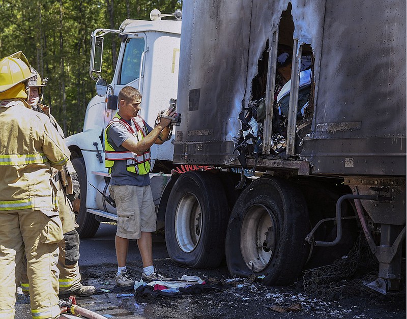 A member of the Morning Star Fire Department uses a thermal imaging device to look for hot spots in a trailer attached to a semi that caught fire on Highway 70 east near the Cloud 9 RV Park shortly before 1:30 p.m. Tuesday. - Photo by Grace Brown of The Sentinel-Record story.lead_photo.caption