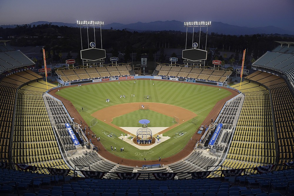 FILE - In Oct. 10, 2018, file photo, Dodger Stadium is shown after sunset in Los Angeles. The Division Series, League Championship Series and World Series will be part of a bubble designed to minimize exposure to the coronavirus. The AL Division Series will be at San Diego's Petco Park and Los Angeles’ Dodger Stadium, and the NL Division Series at Arlington's Globe Life and Houston’s Minute Maid Park. (AP Photo/Mark J. Terrill, File)