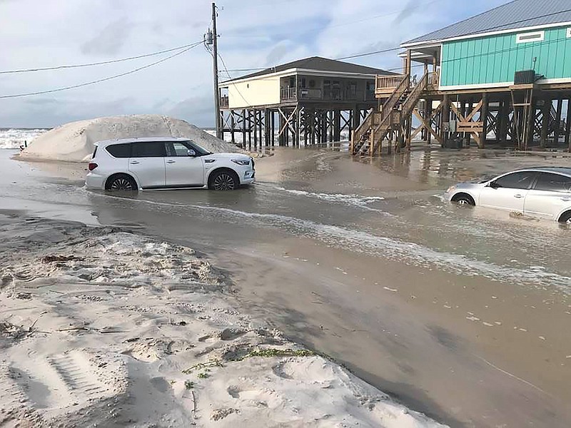 This photo provided by Dauphin Island Mayor Jeff Collier shows cars stranded in the sand, as flooding continues in Tonty Court on Dauphin Island, Ala., Monday, Sept 14, 2020, as Sally closes in on the Gulf Coast. (Jeff Collier via AP)