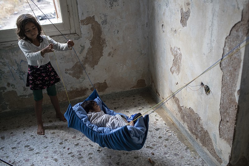 A two-month old baby from Afghanistan sleeps at an abandoned building near Mytilene town, on the northeastern island of Lesbos, Greece, Tuesday, Sept. 15, 2020.  Just over 6% of people have been rehoused, following a recent fire that destroyed Greece's biggest camp for refugees and migrants making 12,500 people homeless, in a new temporary facility under construction on the island of Lesbos. (AP Photo/Petros Giannakouris)