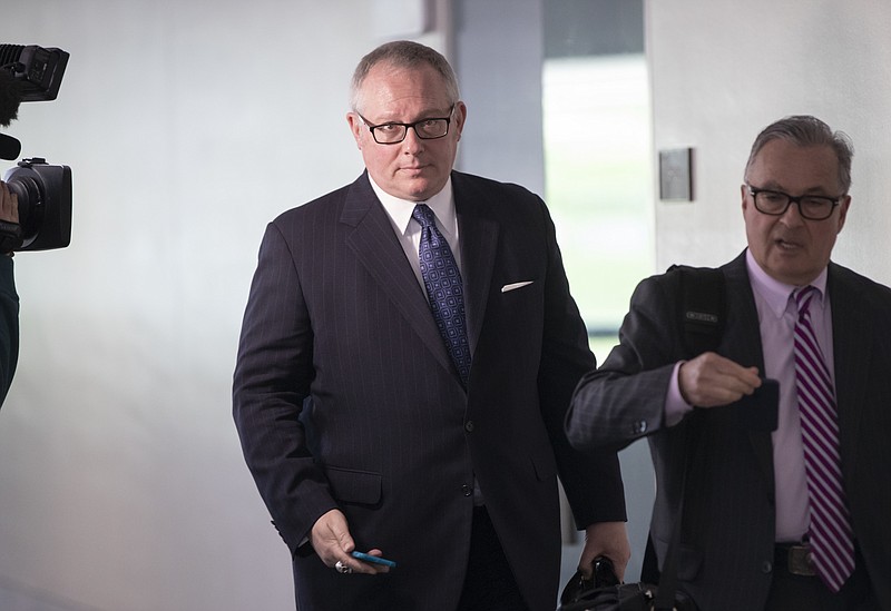 FILE - In this May 1, 2018, file photo, Former Donald Trump campaign official Michael Caputo, left, joined by his attorney Dennis C. Vacco, leaves after being interviewed by Senate Intelligence Committee staff investigating Russian meddling in the 2016 presidential election, on Capitol Hill in Washington. A House subcommittee examining President Donald Trump’s response to the coronavirus pandemic is launching an investigation into reports that political appointees have meddled with routine government scientific data to better align with Trump’s public statements. The Democrat-led subcommittee said Sept. 14, 2020 that it is requesting transcribed interviews with seven officials from the Centers for Disease Control and Prevention and the Department of Health and Human Services, including communications aide Michael Caputo. (AP Photo/J. Scott Applewhite, File)