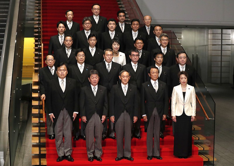Japan's Prime Minister Yoshihide Suga, front center, and his cabinet ministers pose for a photo session at Suga's official residence in Tokyo, Japan, Wednesday, Sept. 16, 2020.  Japan's Parliament elected Suga as prime minister Wednesday, replacing long-serving leader Shinzo Abe with his right-hand man. (Issei Kato/Pool Photo via AP)