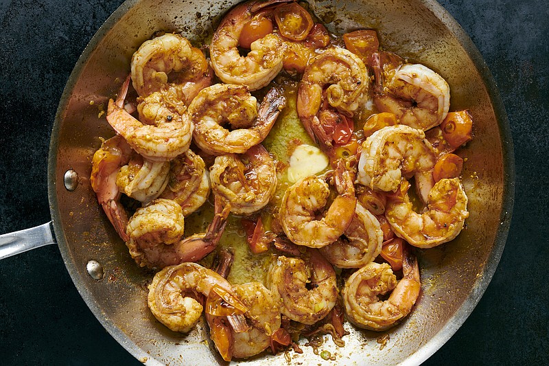 Adding a handful of tomatoes to this take on shrimp scampi makes for a bright, full-flavored meal that’s speedy and complex. (The New York Times/David Malosh)