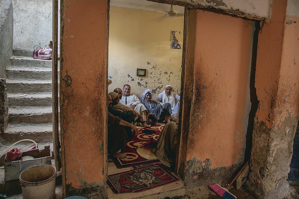 55-year-old Egyptian farmer Makhluf Abu Kassem, left, sits with farmers in his home, in Second Village, Qouta town, Fayoum, Egypt, Saturday, Aug. 8, 2020. Abu Kassem fears that a dam Ethiopia is building on the Blue Nile, the Nile's main tributary, could add to the severe water shortages already hitting his village if no deal is struck to ensure a continued flow of water. "The dam means our death," he said. (AP Photo/Nariman El-Mofty)