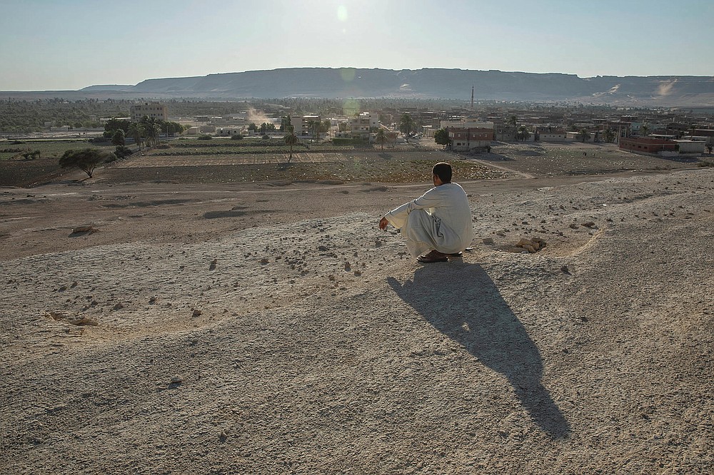 A farmer looks at the general view of Second Village, Qouta town, Fayoum, Egypt, Wednesday, Aug. 5, 2020. Egypt's farmers already face severely stretched water resources due to years of mismanagement and increasing population. Now they worry about the impact of Ethiopia's massive dam project on the Blue Nile, the main tributary feeding the Nile River. (AP Photo/Nariman El-Mofty)