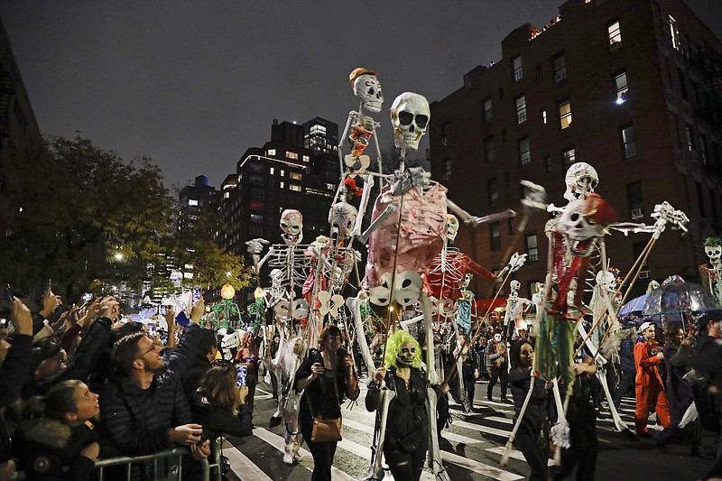 FILE - Revelers march during the Greenwich Village Halloween Parade in New York on Oct. 31, 2019. The holiday so many look forward to each year is going to look different in the pandemic as parents and the people who provide Halloween fun navigate a myriad of restrictions and safety concerns. (AP Photo/Frank Franklin II, File) story.lead_photo.caption