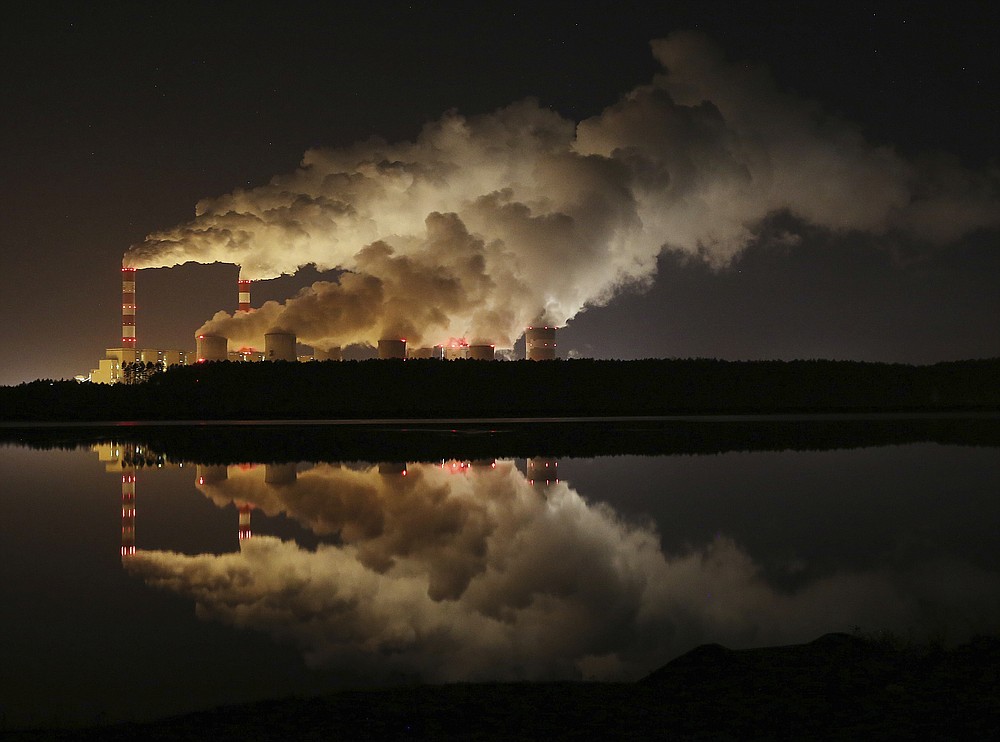 FILE -- In this Wednesday, Nov. 28, 2018 file photo clouds of smoke are pictured over Europe's largest lignite power plant in Belchatow, central Poland. Government stimulus programs to pull the world out of the coronavirus pandemic offer “a tremendous opportunity” to build a clean-energy economy, former California governor Arnold Schwarzenegger said Thursday, calling on governments not to “invest in the past." Speaking video link from Los Angeles to the Austrian World Summit in Vienna, Schwarzenegger said that “forward-looking decisions” are needed now as trillions are being poured into rebuilding economies around the globe.A group of Greenpeace environment activists have climbed its 180-meter smokestack to spur participants in next week's global climate summit in Poland into taking decisions on limiting the use of coal.(AP Photo/Czarek Sokolowski, file)