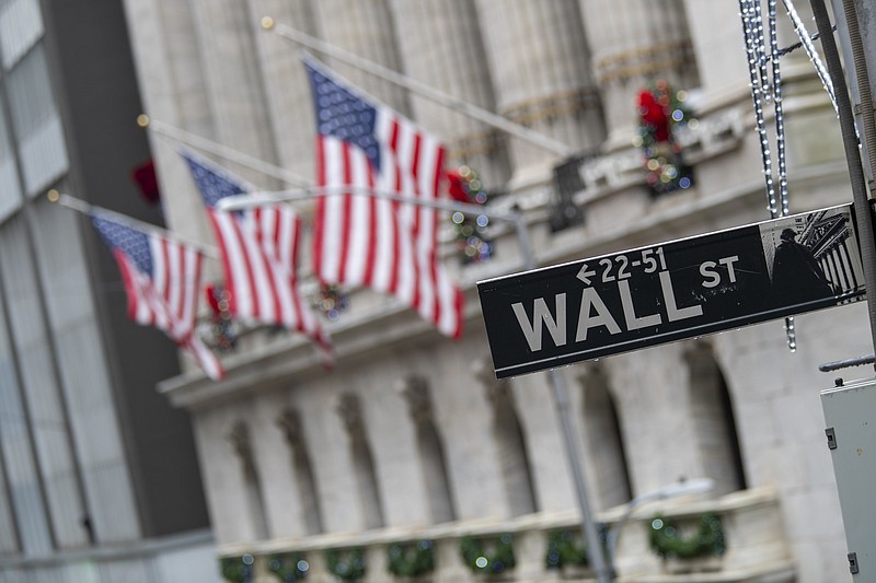 FILE - In this Jan. 3, 2020 file photo, the Wall St. street sign is framed by American flags flying outside the New York Stock Exchange in New York. (AP Photo/Mary Altaffer, File)