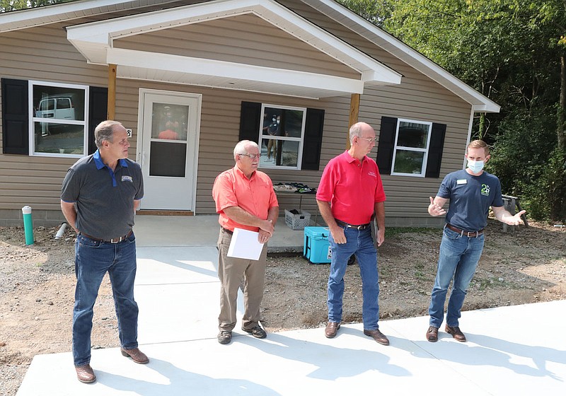 From left, state Reps. Les Warren, Richard McGrew and Bruce Cozart listen as Garland County Habitat for Humanity board President Todd Green speaks Friday during a ceremony recognizing the 25th anniversary of the organization. - Photo by Richard rasmussen of The Sentinel-Record