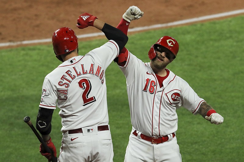Cincinnati Reds' Nick Castellanos, left, and Tucker Barnhart celebrates Barnhart's solo home run during the third inning of the team's baseball game against the Chicago White Sox in Cincinnati, Friday, Sept. 18, 2020. (AP Photo/Aaron Doster)