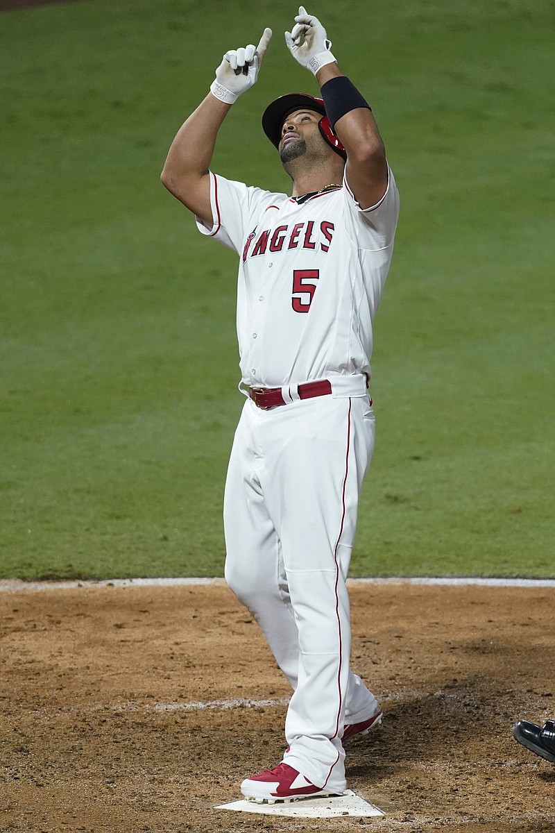 Los Angeles Angels Albert Pujols points skyward after hitting a solo home run during the seventh inning of Friday's game against the Texas Rangers in Anaheim, Calif. - Photo by Ashley Landis of The Associated Press