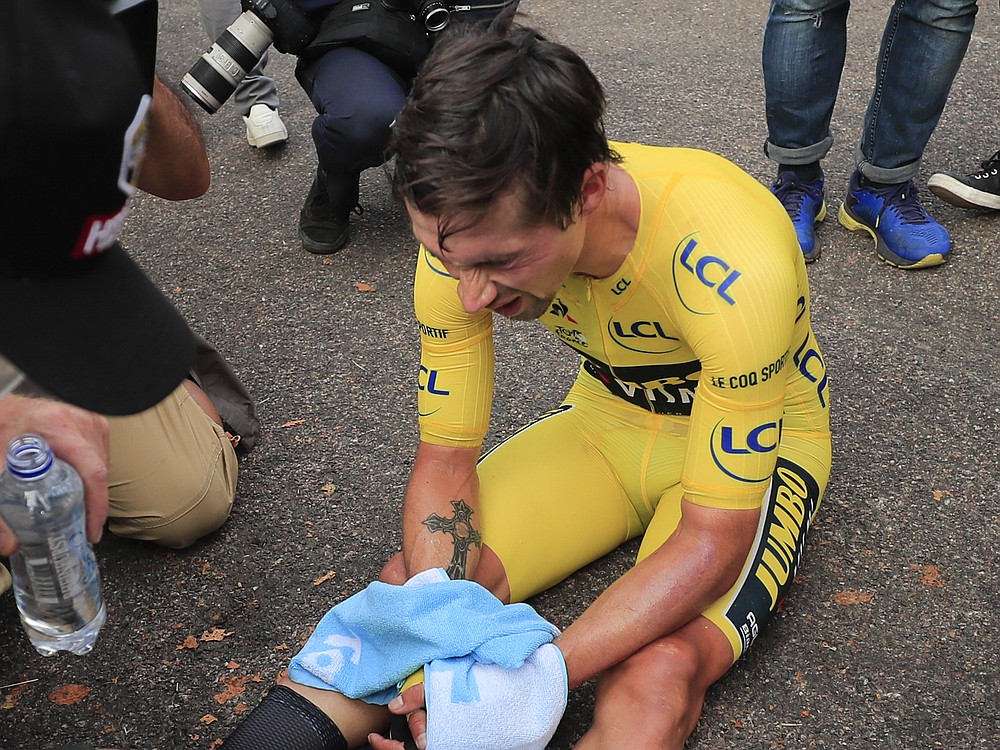 Slovenia's Primoz Roglic sits on the road after losing the overall leader's yellow jersey in stage 20 of the Tour de France cycling race, an individual time trial over 36.2 kilometers (22.5 miles), from Lure to La Planche des Belles Filles, France, Saturday, Sept. 19, 2020. (Christophe Petit-Tesson/Pool via AP)
