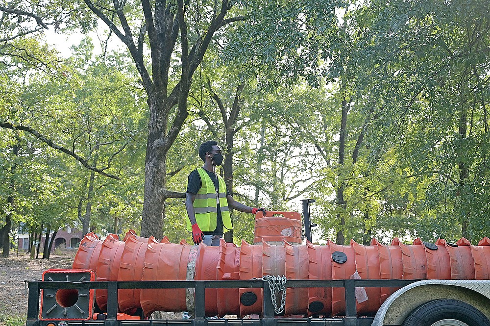 Maxime Pierre, Deputy Director of Recreation Services for Little Rock Parks and Rec, helps lay out traffic cones and barrels as he and a group of volunteers work to establish a bike lane along Jonesboro Drive between Children's Library, Little Rock Zoo, and War Memorial Park on Saturday, Sept. 19, 2020. The project, which will stay up until October 17, is the first implementation action of the new Safe Routes to Parks Plan, which is focused on ensuring people can safely enjoy the physical, social, and mental health benefits of parks, according to a news release.
(Arkansas Democrat-Gazette / Stephen Swofford)