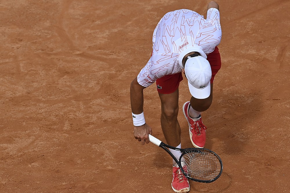 Serbia's Novak Djokovic checks his broken racket during is match with Germany's Dominik Koepfer during their quarterfinals at the Italian Open tennis tournament, in Rome, Saturday, Sept. 19, 2020. (Alfredo Falcone/LaPresse via AP)