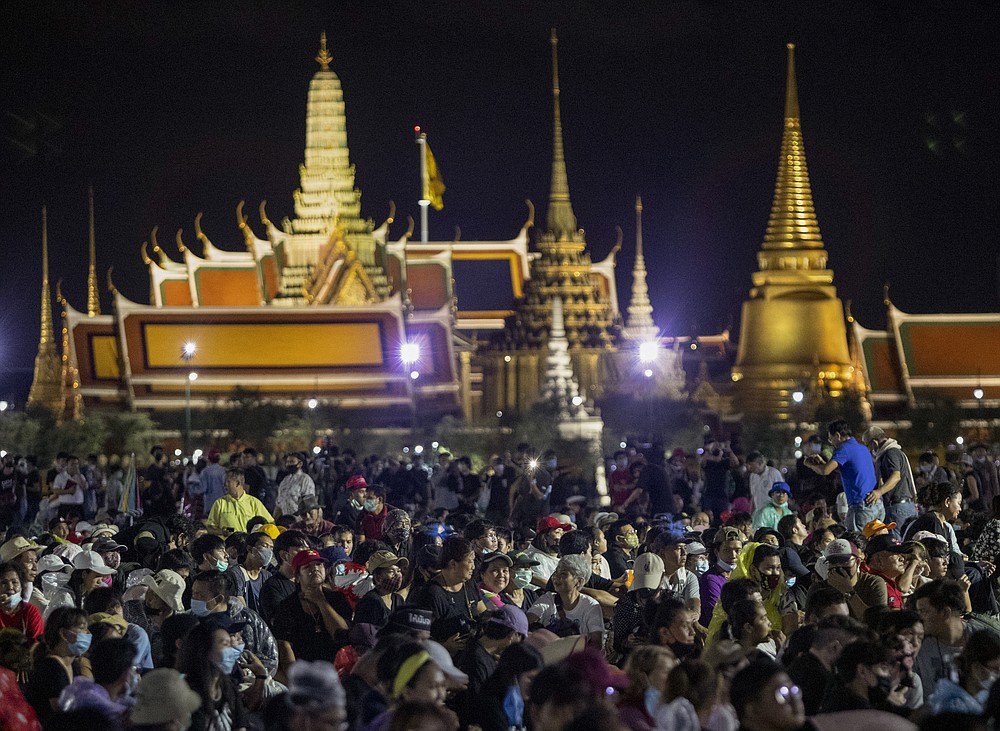 Pro-democracy demonstrators attend a protest at Sanam Luang with The Grand Palace lit up in the background in Bangkok, Thailand, Saturday, Sept. 19, 2020. Thousands of demonstrators turned out Saturday for a rally to support the student-led protest movement's demands for new elections and reform of the monarchy. (AP Photo/Sakchai Lalit)