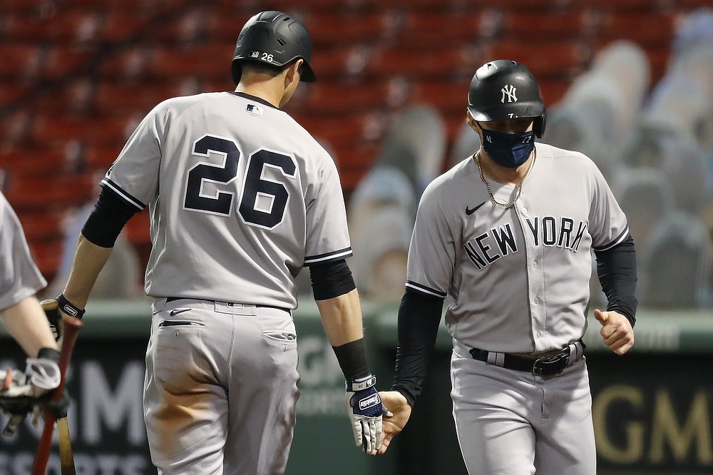 New York Yankees' Clint Frazier celebrates with DJ LeMahieu (26) after scoring on a single by Kyle Higashioka during the fourth inning of a baseball game against the Boston Red Sox, Saturday, Sept. 19, 2020, in Boston. (AP Photo/Michael Dwyer)