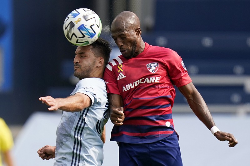 Sporting Kansas City defender Luis Martins, left, heads the ball against FC Dallas forward Fafa Picault, right, during the first half of Saturday's match in Kansas City, Kan. - Photo by Orlin Wagner of The Associated Press