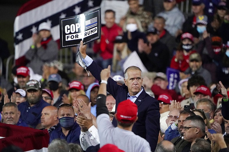 Sen. Tom Tillis, R-N.C. holds a sign as President Donald Trump speaks at a campaign rally, Saturday, Sept. 19, 2020 at the Fayetteville Regional Airport in Fayetteville, N.C. (AP Photo/Chris Carlson)