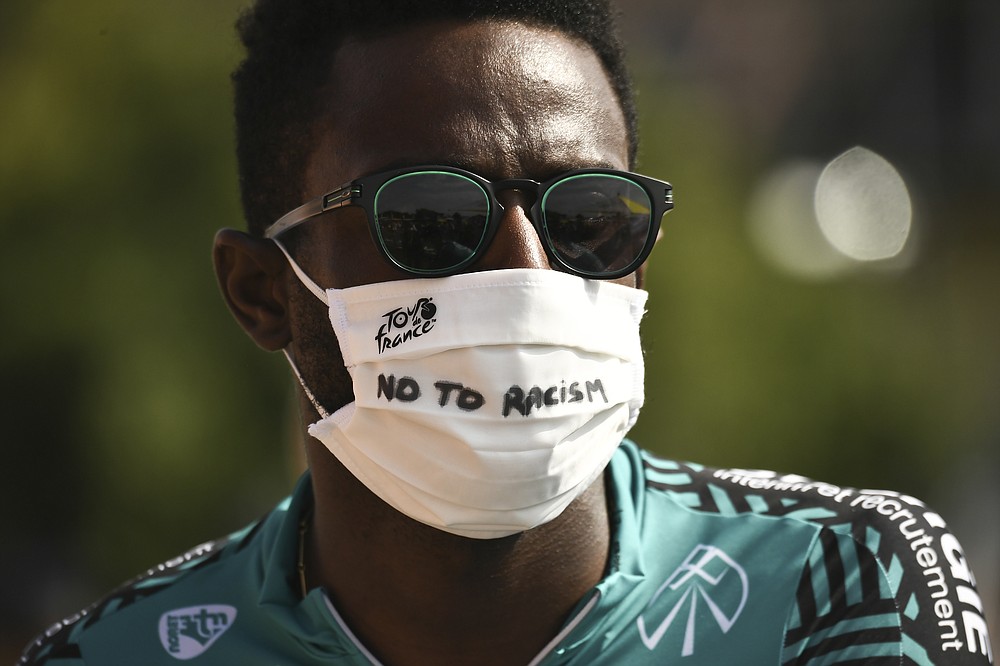 France's Kevin Reza wears a face mask reading "No To Racism" as he arrives for the start of the twenty-first and last stage of the Tour de France cycling race over 122 kilometers (75.8 miles), from Mantes-La-Jolie to Paris, France, Sunday, Sept. 20, 2020. (Marco Bertorello/Pool via AP)