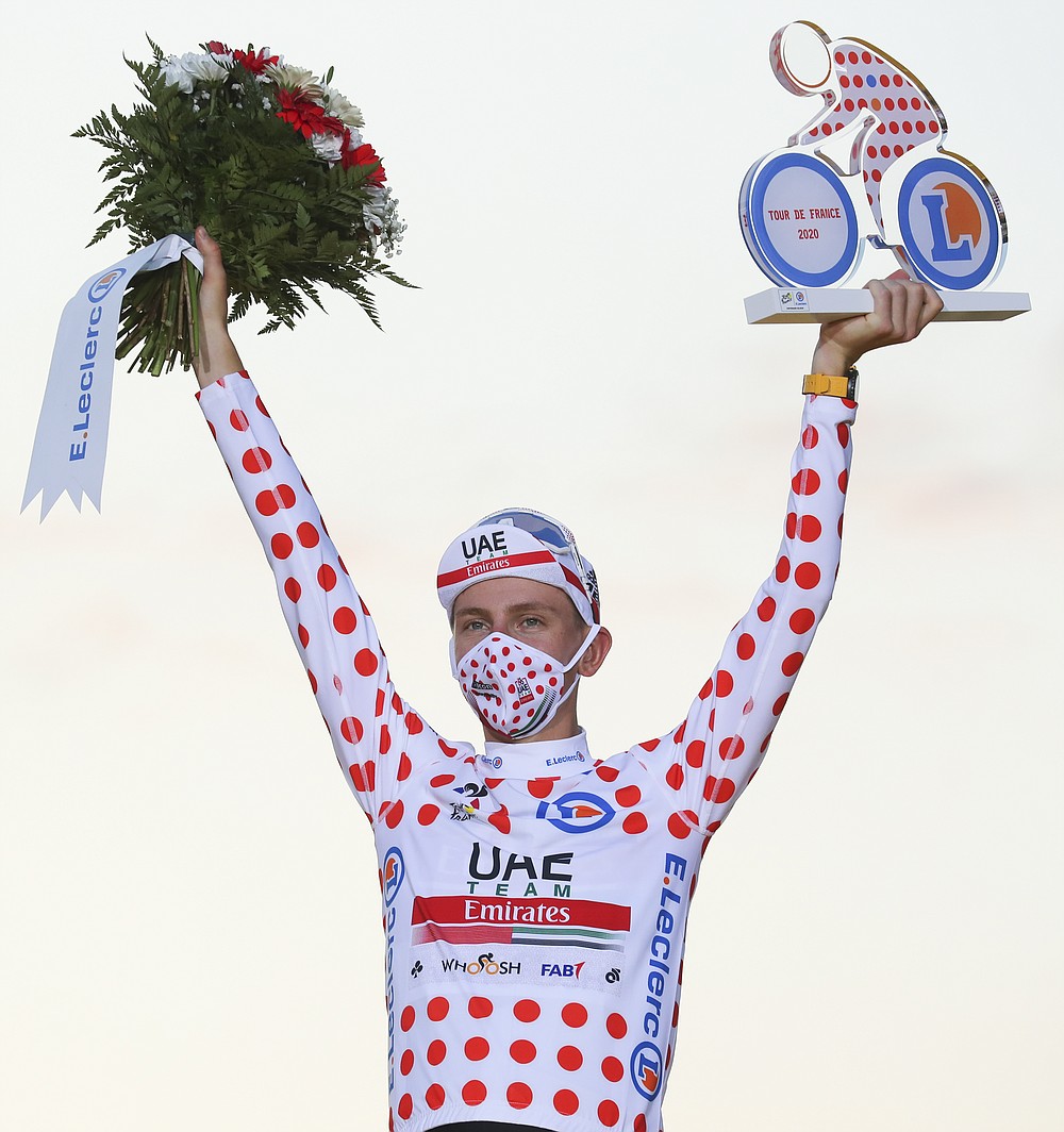 Tour de France winner Slovenia's Tadej Pogacar, who also won the best climber's dotted jersey, celebrates on the podium after the twenty-first and last stage of the Tour de France cycling race over 122 kilometers (75.8 miles), from Mantes-la-Jolie to Paris, France, Sunday, Sept. 20, 2020. (AP Photo/Thibault Camus)