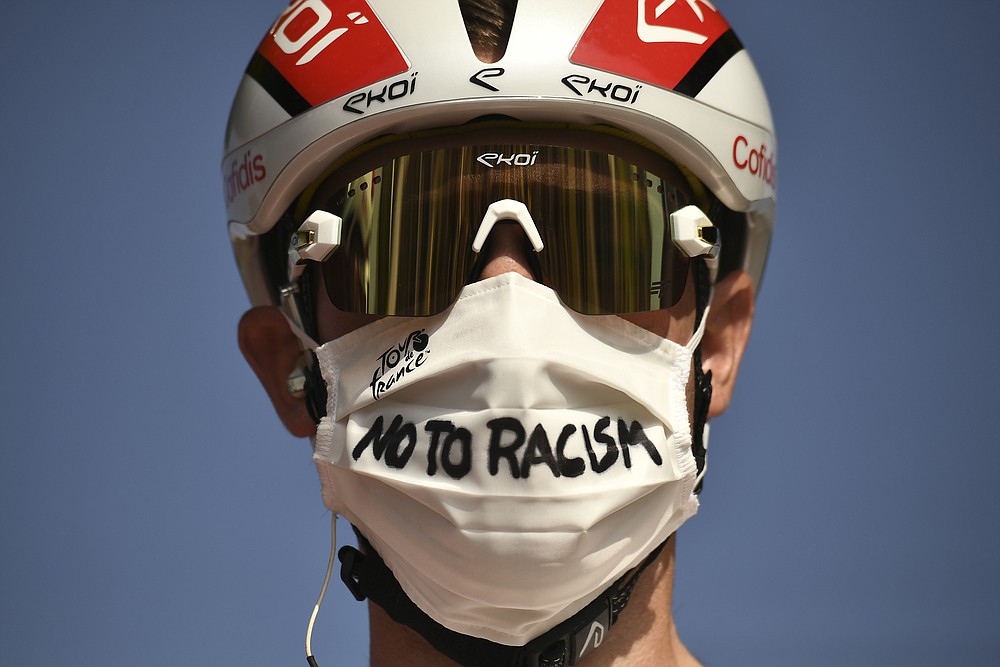 Italy's Elia Viviani wears a face mask reading "No To Racism" as he arrives for the start of the twenty-first and last stage of the Tour de France cycling race over 122 kilometers (75.8 miles), from Mantes-La-Jolie to Paris, France, Sunday, Sept. 20, 2020. (Marco Bertorello/Pool via AP)