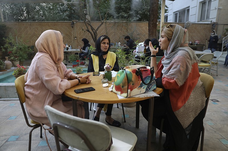 People spend their afternoon in a cafe in Tehran, Iran, Sunday, Sept. 20, 2020. Iran's president dismissed U.S. efforts to restore all U.N. sanctions on the country as mounting economic pressure from Washington pushed the local currency down to its lowest level ever on Sunday. (AP Photo/Vahid Salemi)