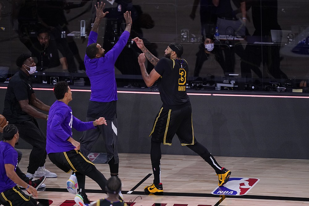 Los Angeles Lakers' Anthony Davis (3) celebrates with teammates after making a 3-point basket at the end of an NBA conference final playoff basketball game against the Denver Nuggets Sunday, Sept. 20, 2020, in Lake Buena Vista, Fla. The Lakers won 105-103. (AP Photo/Mark J. Terrill)