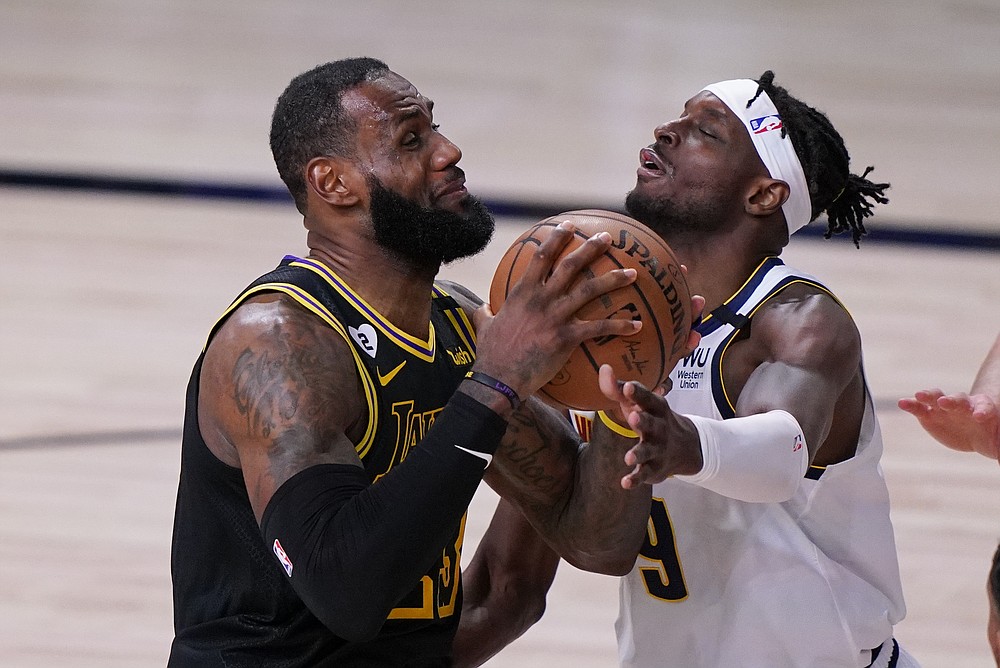 Los Angeles Lakers' LeBron James, left, drives to the basket over Denver Nuggets' Jerami Grant (9) during the second half of an NBA conference final playoff basketball game Sunday, Sept. 20, 2020, in Lake Buena Vista, Fla. (AP Photo/Mark J. Terrill)