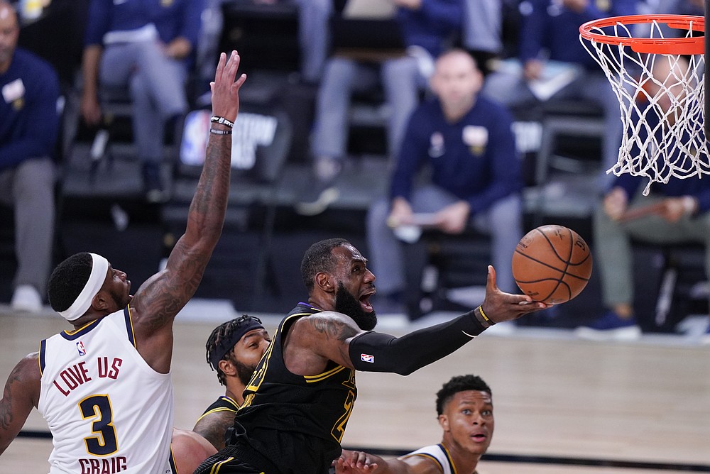 Los Angeles Lakers' LeBron James drives to the basket ahead of Denver Nuggets' Torrey Craig (3) during the second half of an NBA conference final playoff basketball game Sunday, Sept. 20, 2020, in Lake Buena Vista, Fla. (AP Photo/Mark J. Terrill)