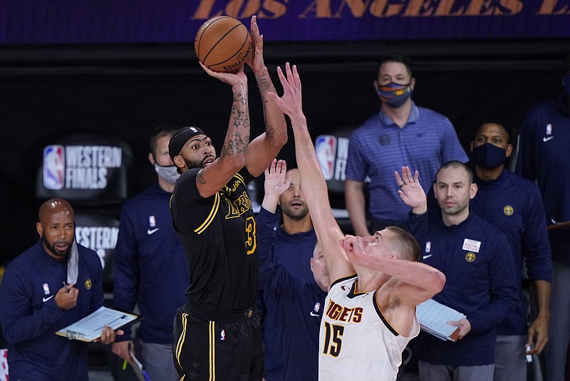 Los Angeles Lakers' Anthony Davis (3) shoots a 3-point basket over Denver Nuggets' Nikola Jokic (15) at the end of an NBA conference final playoff basketball game Sunday, Sept. 20, 2020, in Lake Buena Vista, Fla. The Lakers won 105-103. (AP Photo/Mark J. Terrill)