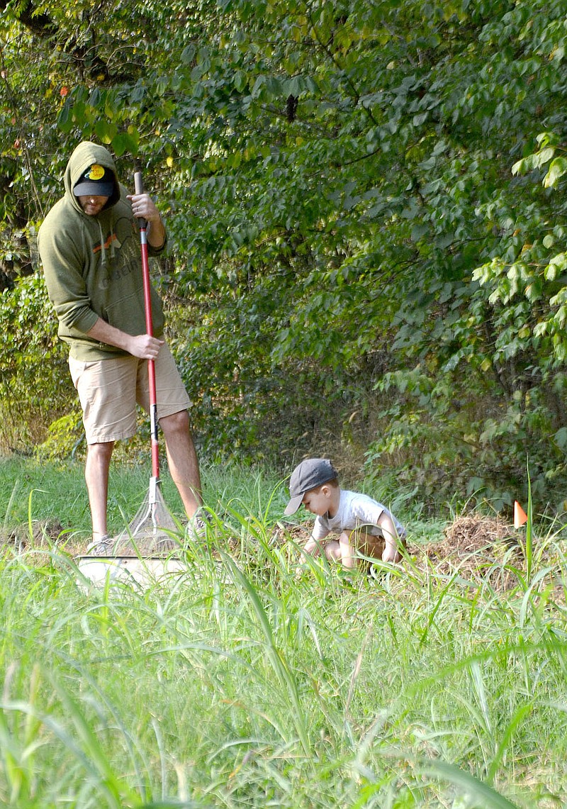 Dallas Eubanks and his son, Quill, 2, work on the bicycle path being constructed at Baker Hayes Park Saturday, Sept. 19, 2020.
