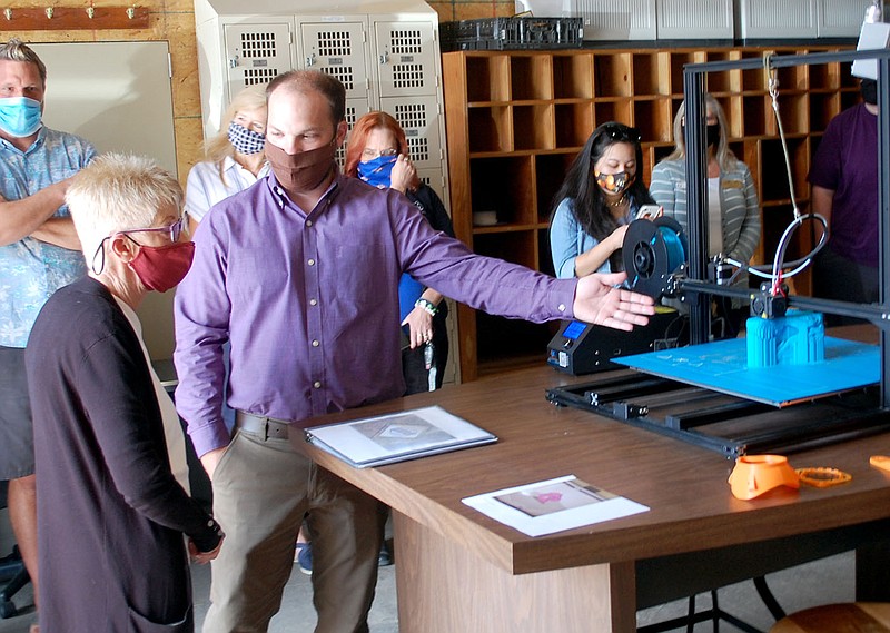 Janelle Jessen/Herald-Leader
Nathan Reed (right), vice president of the Siloam Springs Chamber of Commerce, shows City Director Carol Smiley the 3D printer in the Chamber's new maker space during the grand opening on Monday.