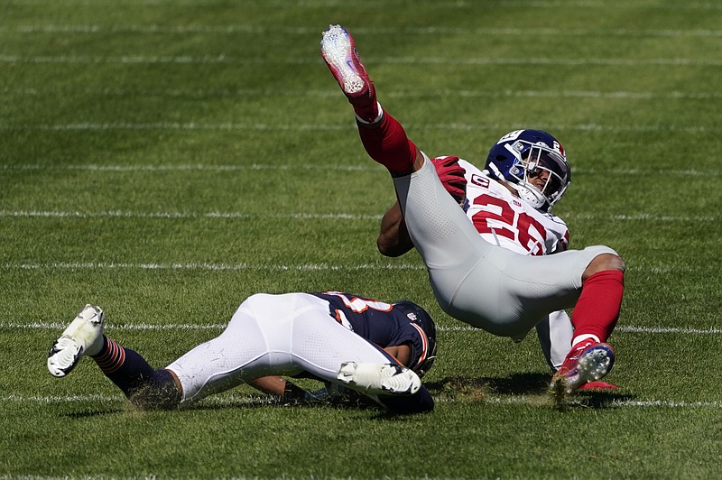 New York Giants running back Saquon Barkley (26) is brought down by Chicago Bears cornerback Kyle Fuller (23) during the first half of an NFL football game in Chicago, Sunday, Sept. 20, 2020. (AP Photo/Charles Rex Arbogast)