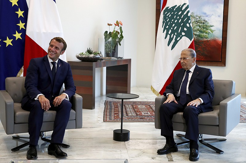 FILE - In this Sept. 1, 2020 file photo, French President Emmanuel Macron, left, smiles as he meets Lebanon's President Michel Aoun at the presidential palace in Baabda, Lebanon, Tuesday, Sept. 1, 2020. In a televised address Monday, Sept. 21, 2020, Aoun warned that the crisis-hit country could be going to “hell” if a new government is not formed. An initiative led by Macron called for a Lebanese government of independent specialists that was to be formed by Sept. 15. (Gonzalo Fuentes/Pool via AP, File)